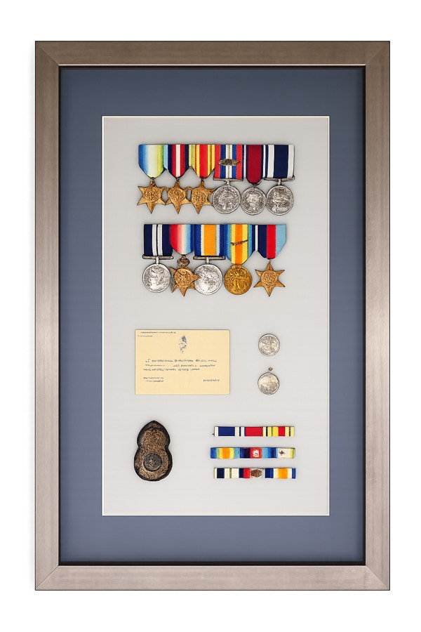 War medals and insignia in a deep box frame with navy mount
